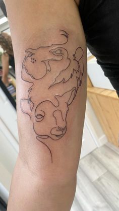 a woman's arm with a tattoo on it that has two lions in the middle