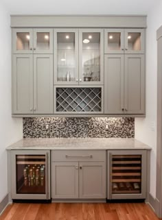 a wine cellar in the middle of a room with wooden floors and cabinets on both sides