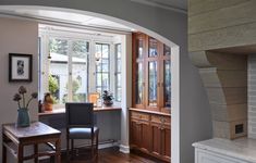 an arched window in the corner of a room with a table and chairs next to it