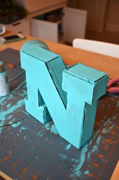 the letter n is made out of plywood and paint on top of a table