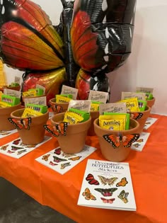 there are many books on the table with butterfly balloons in the backgrouds