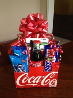 a coca - cola box filled with assorted snacks and candy sits on a table