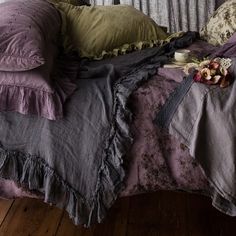 a bed covered in purple and green linens