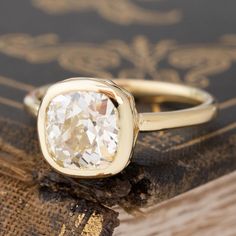 a close up of a ring on top of a book with a diamond in it