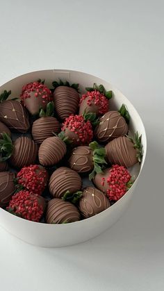 a white bowl filled with chocolate covered strawberries