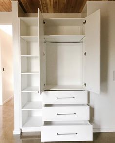 an empty white closet with drawers and shelves