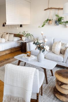 a living room filled with white furniture and lots of pillows on top of it's covers