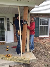 two men working on the side of a house