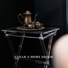 a metal tea pot sitting on top of a glass table