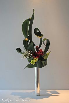 a vase filled with lots of flowers on top of a white tablecloth covered floor