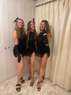 three young women dressed in flappers and garb posing for the camera with their arms around each other