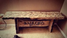 a bench made out of wood with writing on the top and bottom, sitting in a room