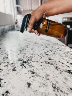 a person holding a bottle on top of a counter