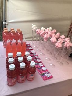 there are many bottles of water and pink flowers on the table at this wedding reception