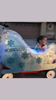 a baby in a sleigh decorated with christmas lights