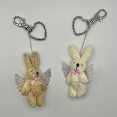 two key chains with small stuffed animals attached to them, one has a pink ribbon on it