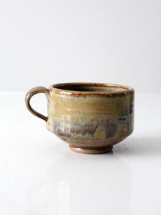 a brown cup sitting on top of a white table