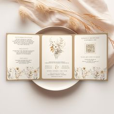 the wedding stationery is laid out on top of a white plate next to some dried flowers