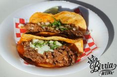 two tacos are sitting on a plate with red and white checkered napkins