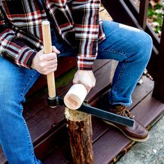 a man sitting on top of a wooden bench holding a mallet