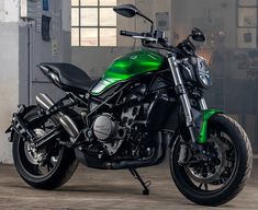 a green and black motorcycle parked in a garage