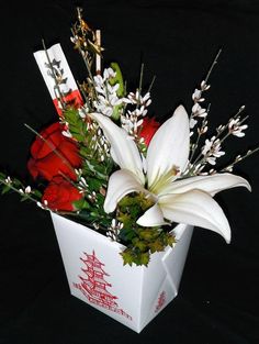 a white and red flower arrangement in a box