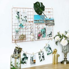 there are pictures hanging on the wall next to a vase with flowers and other decorations