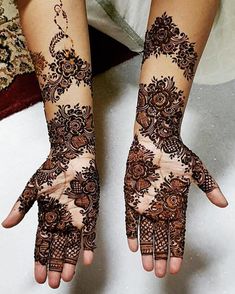 two hands with henna tattoos on them