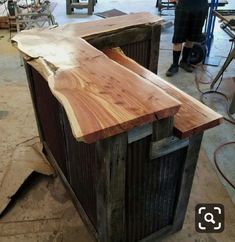 a man standing next to a wooden counter in a room filled with woodworking tools