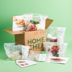 a box filled with food sitting on top of a green table next to other items