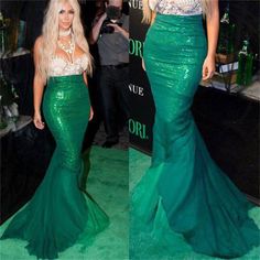 two women in green dresses standing next to each other on a green carpeted floor