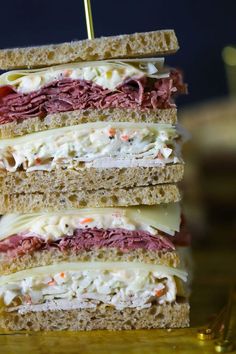 a stack of sandwiches sitting on top of a wooden table