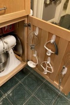 a kitchen cabinet with many attachments and mixers on the door handle in it