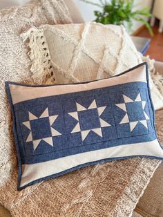 a blue and white pillow sitting on top of a couch