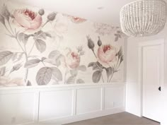 an empty room with floral wallpaper and chandelier