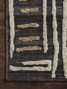 a black and white area rug on a wooden floor with wood grains in the background