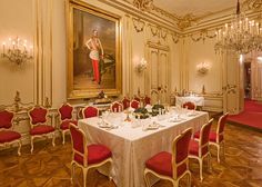 a fancy dining room with red chairs and white table cloths