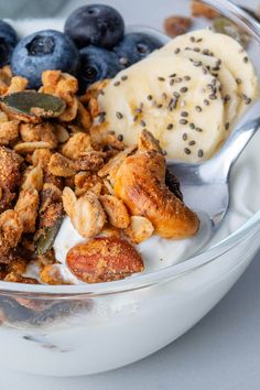 a bowl filled with granola, blueberries and bananas