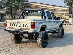 a white toyota pickup truck parked in front of a building