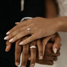 two people holding each other's hands with wedding rings on their fingers in front of them