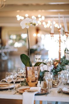 the table is set with silverware and flowers