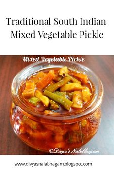 a glass jar filled with mixed vegetable pickles on top of a wooden table next to a