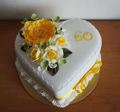 a heart shaped cake decorated with flowers and the number sixty on it's side