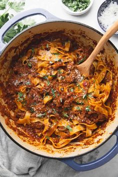 a pot filled with pasta and sauce on top of a table