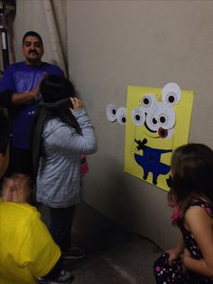 a group of people standing next to each other near a wall with pictures on it