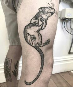 a man's leg with a rat tattoo on it