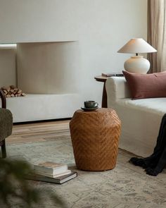 a living room filled with furniture and a lamp on top of a wooden table next to a white couch