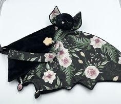 a bat with flowers on it and a cat toy attached to it's back