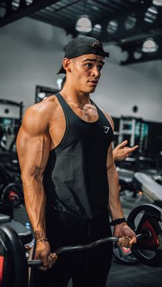 a man holding a barbell in a gym