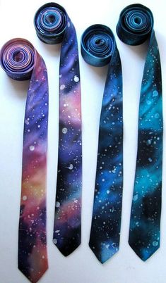 three ties with different designs on them sitting next to each other in the shape of spirals